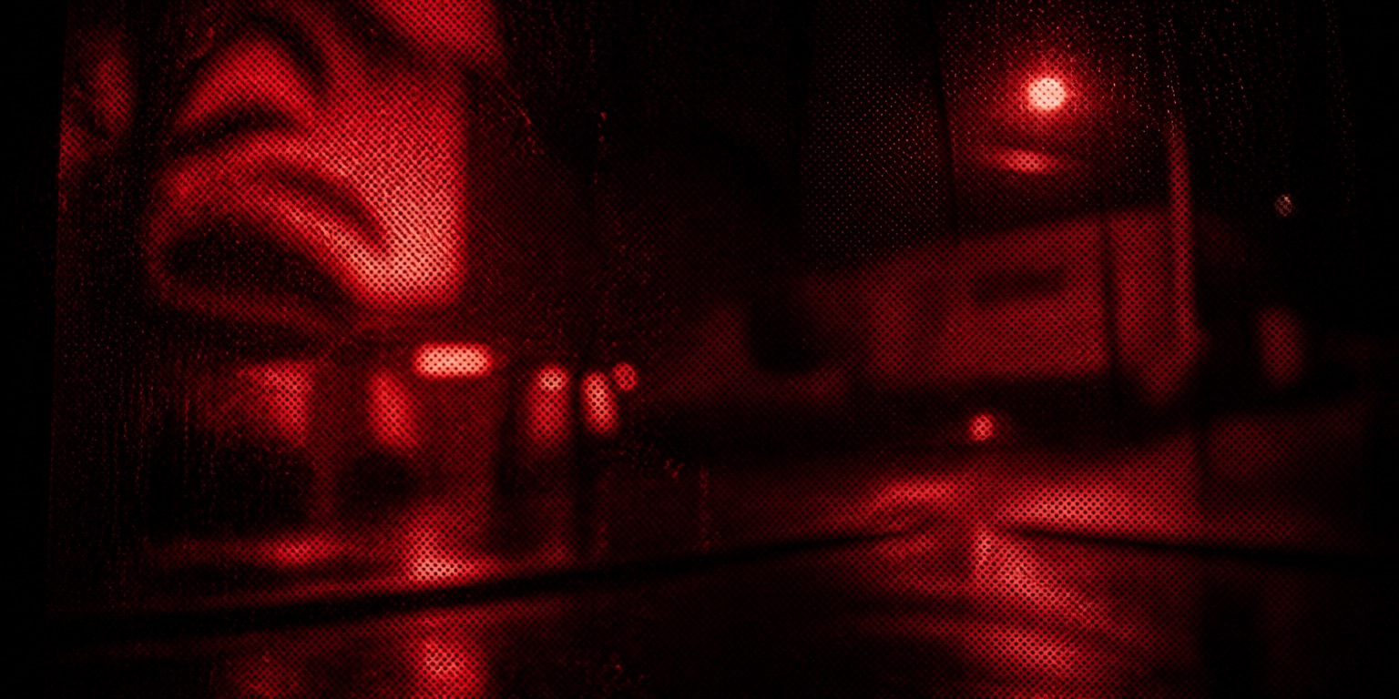 A street corner at night through a rain-wet window, dissolved into red light